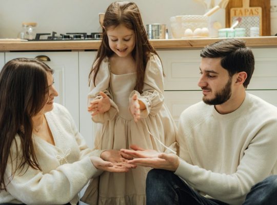 A group of people sitting around in a kitchen