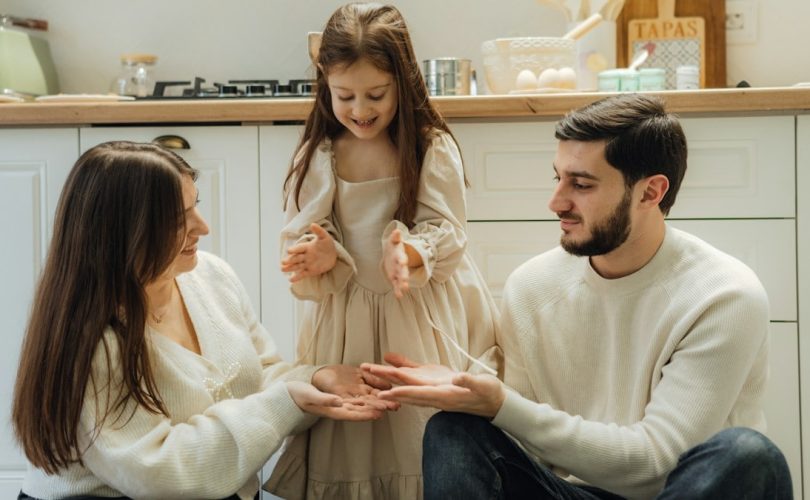A group of people sitting around in a kitchen
